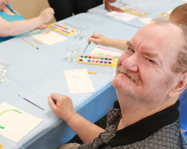 male adult learning independent living skills at harmony day support